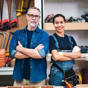 一名身穿牛仔工作服的中年男子和女子站在手工具架前